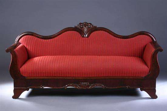 Appraisal: VICTORIAN MAHOGANY SERPENTINE SOFA th century with red striped upholstery