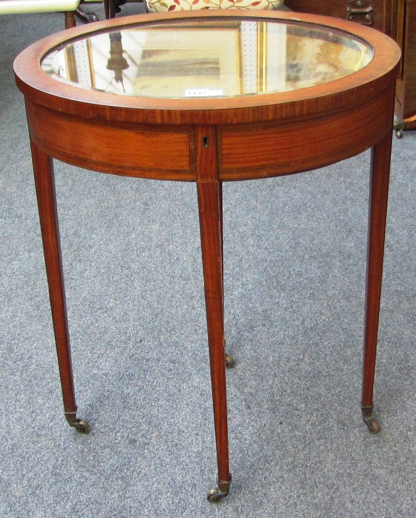 Appraisal: An Edwardian inlaid mahogany oval vertu table on tapering square