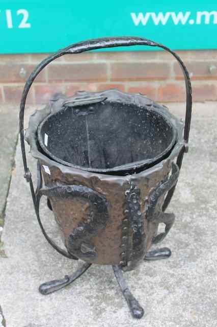 Appraisal: A STYLISED HAMMERED COPPER COAL BUCKET on wrought iron stand