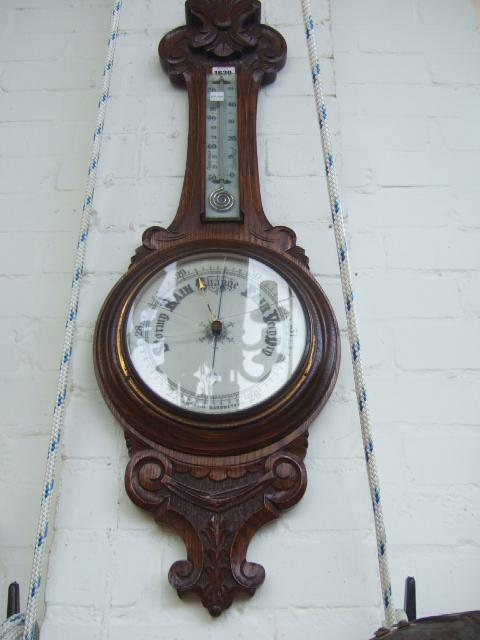 Appraisal: A late Victorian oak framed wheel barometer thermometer with carved