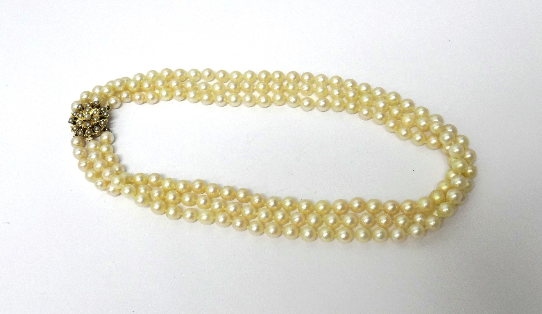 Appraisal: A three row necklace of uniform cultured pearls on a