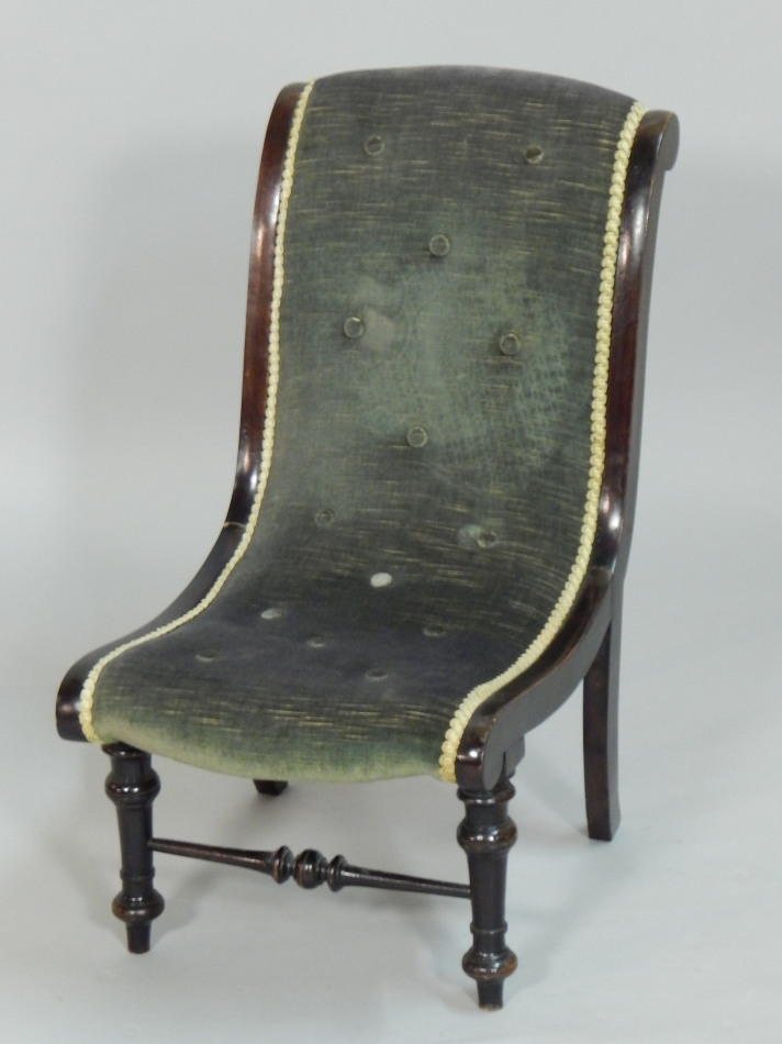 Appraisal: A late Victorian ebonised nursing chair with a padded and