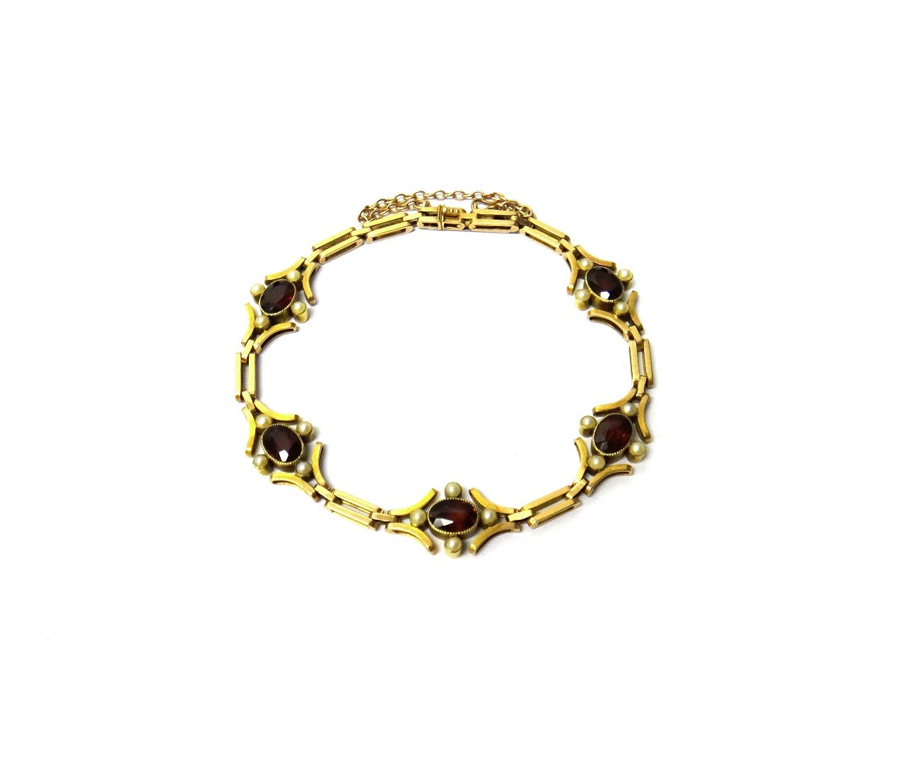 Appraisal: A gold garnet and seed pearl set bracelet designed as