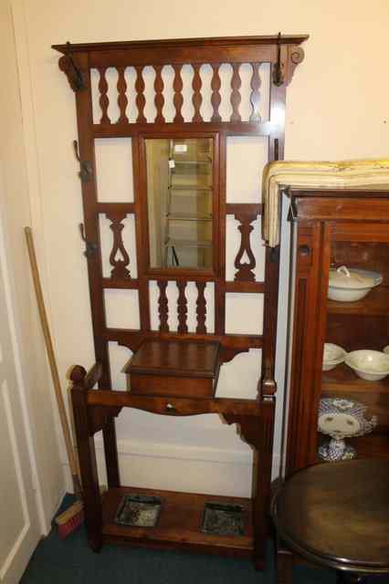 Appraisal: AN EDWARDIAN WALNUT HALL STAND fitted with central mirror panel