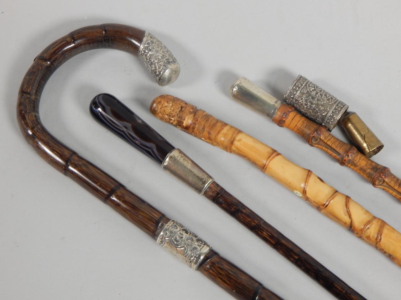 Appraisal: Four walking canes to include an onyx example with yellow