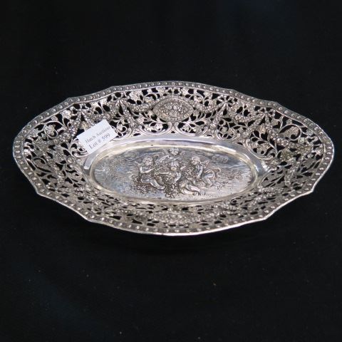 Appraisal: European Silver Oval Bread Dish elaborate scene with cherubs surrounded