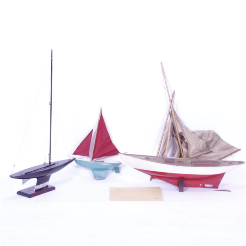 Appraisal: Three vintage wooden model boats and handmade sail pattern Racing