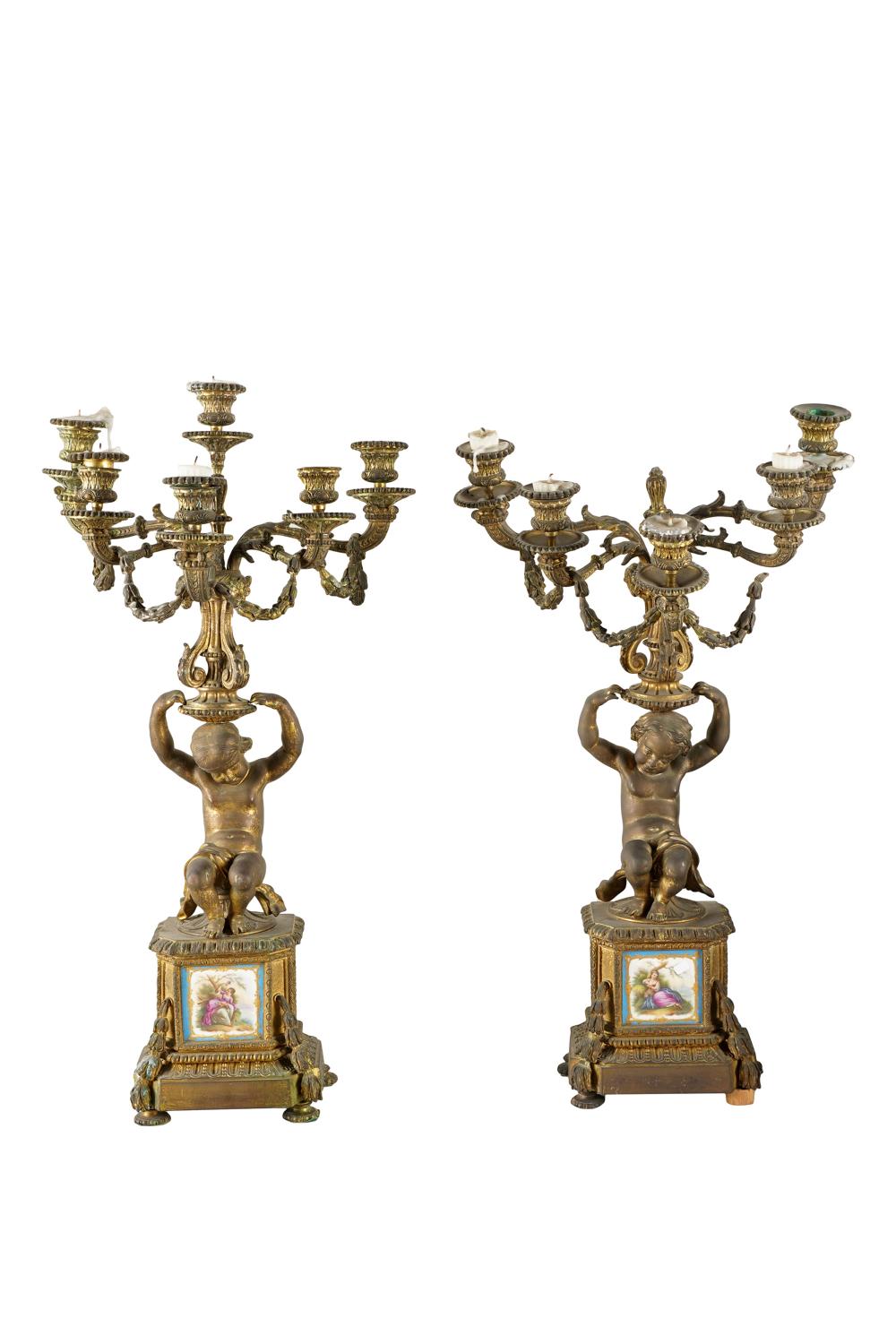 Appraisal: PAIR OF GILT METAL FIGURAL CANDELABRAeach on a Sevres-style porcelain-inset