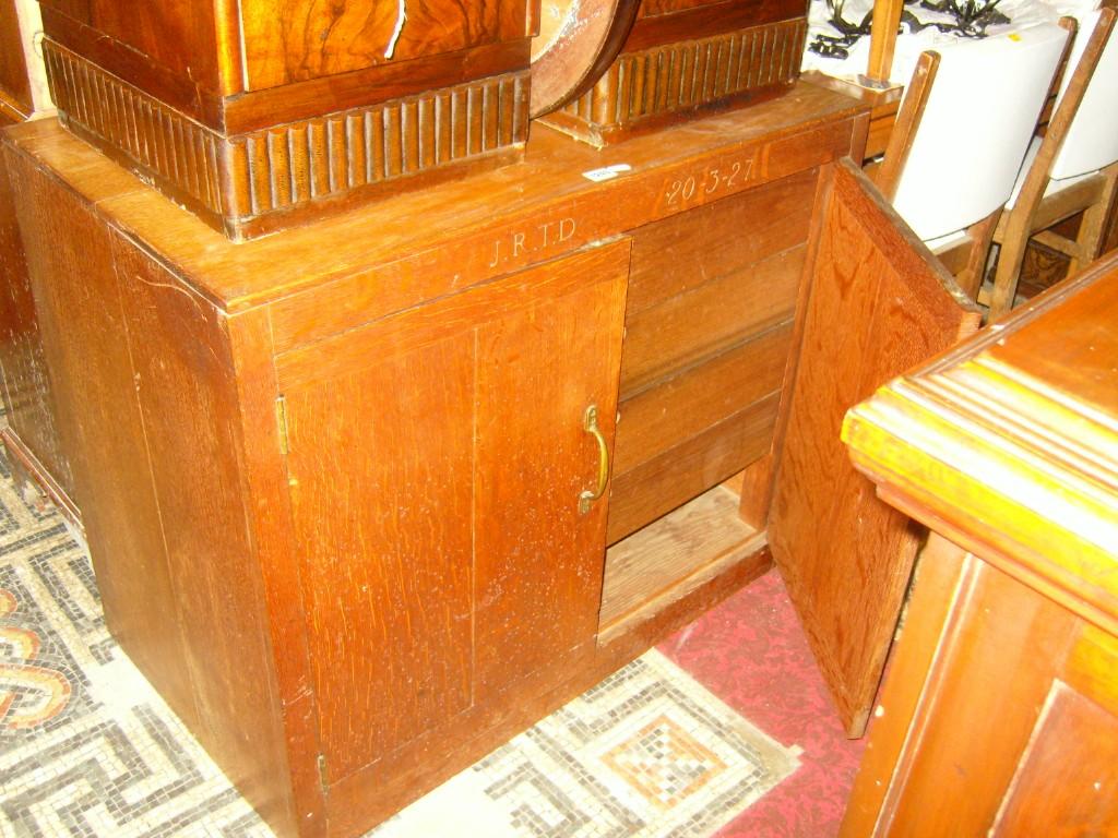 Appraisal: An Art Deco oak cupboard enclosed by two panelled doors