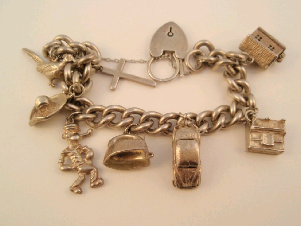 Appraisal: A silver curb bracelet with eight attached charms g all