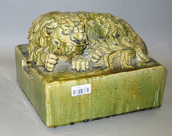 Appraisal: A green glazed pottery recumbent shishi dog Shaped as a