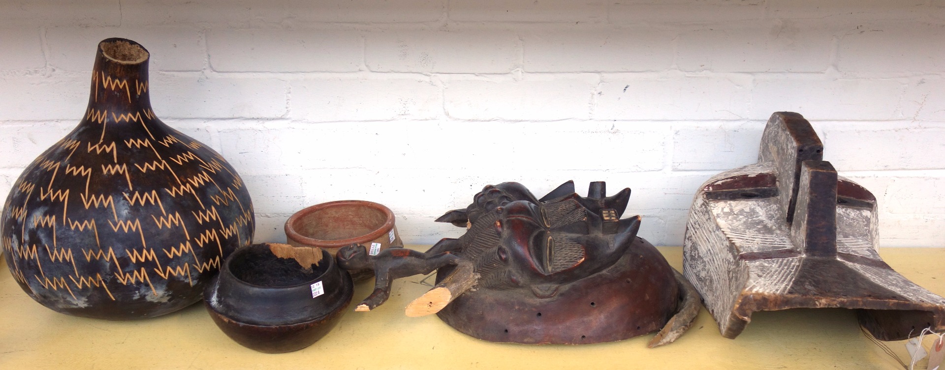 Appraisal: Two African masks circa a carved gourd a terracotta bowl