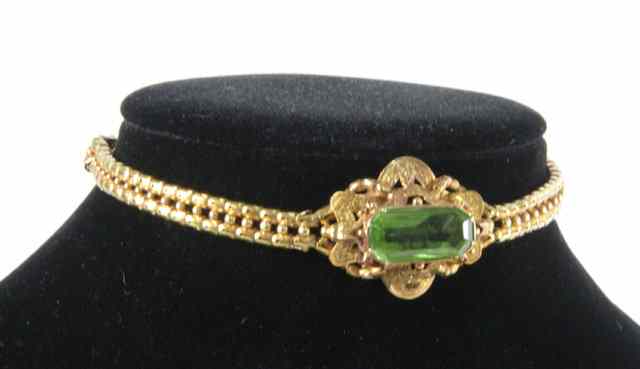 Appraisal: An articulated link bracelet centred by a peridot in an