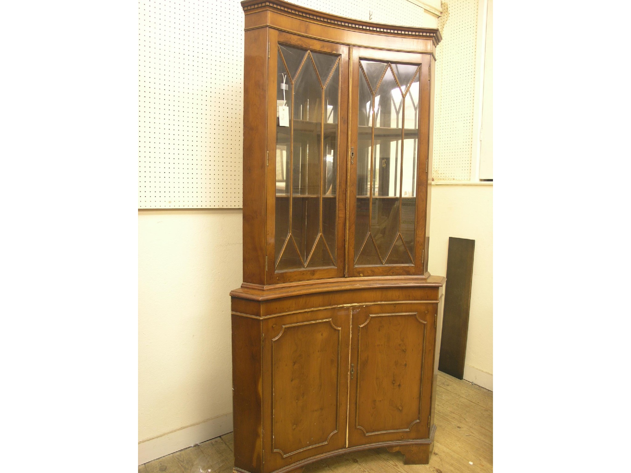 Appraisal: A yew-veneered corner cabinet floor-standing pair of glazed doors enclosing