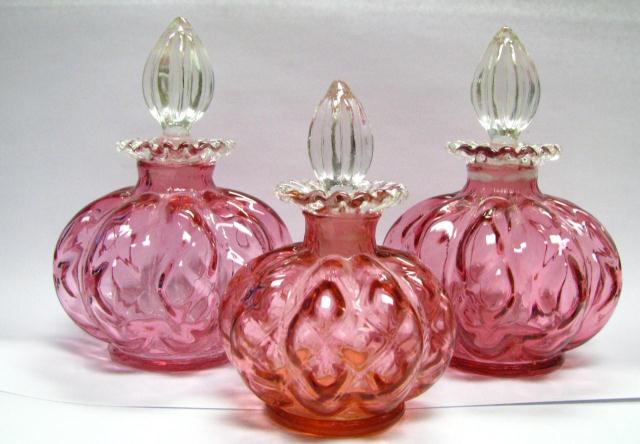 Appraisal: Three cranberry glass bottles with clear stoppers