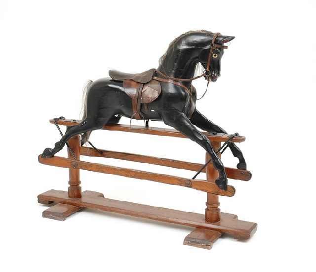 Appraisal: A VINTAGE ROCKING HORSE The black lacquered horse with leather