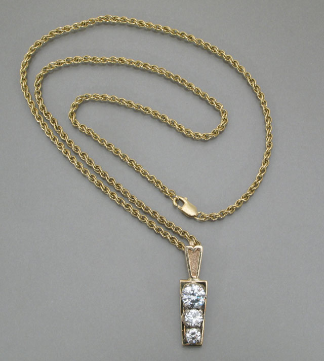 Appraisal: DIAMOND AND FOURTEEN KARAT GOLD PENDANT the vertical trapezoidal gold