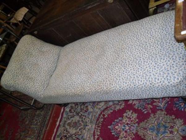 Appraisal: An upholstered chaise lounge on turned supports