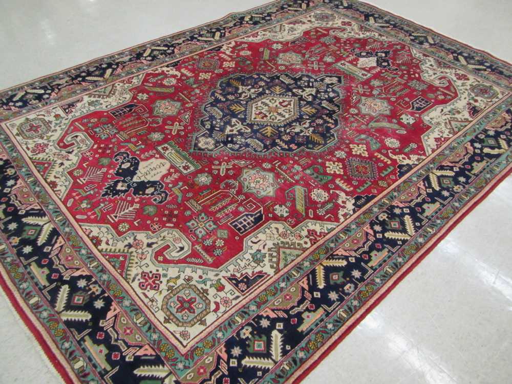 Appraisal: SEMI-ANTIQUE PERSIAN CARPET hand knotted in a central blue geometric