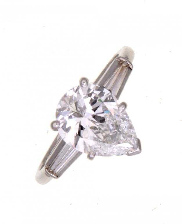 Appraisal: A DIAMOND RING with a pear shaped diamond flanked by