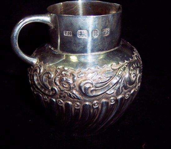 Appraisal: A small embossed cream jug with spiral fluted decoration cm