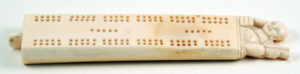 Appraisal: A carved ivory cribbage board of tapered rectangular form surmounted