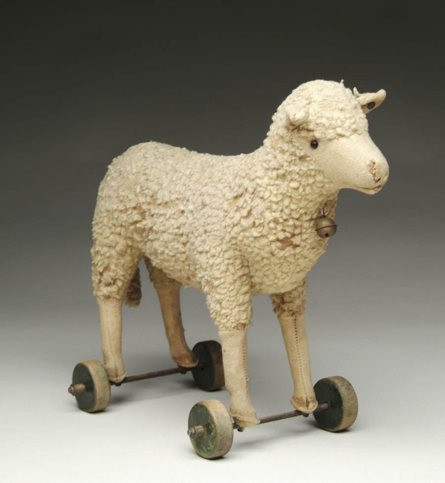 Appraisal: STEIFF SHEEP ON WHEELS Wooly Steiff lamb stuffed with straw