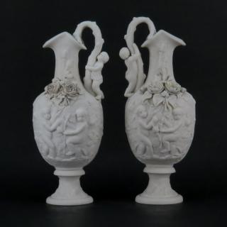 Appraisal: Pair of Victorian Style Bisque Porcelain Putti Figural Relief Ewers