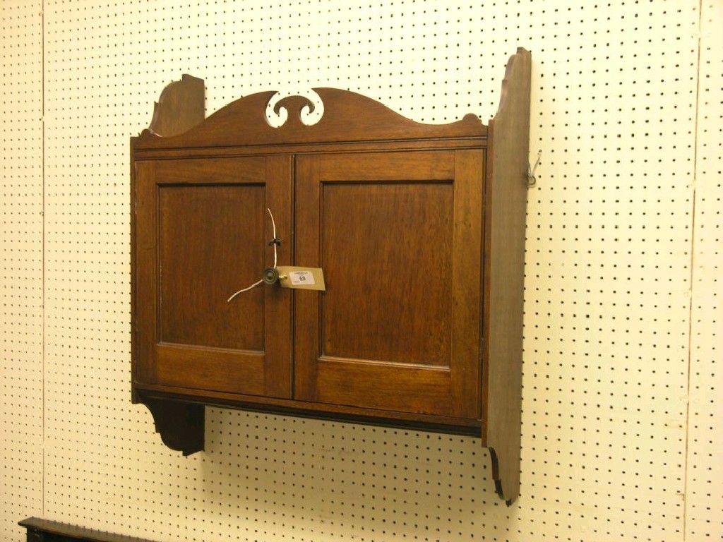 Appraisal: A late Victorian red walnut wall hanging cupboard shaped pediment