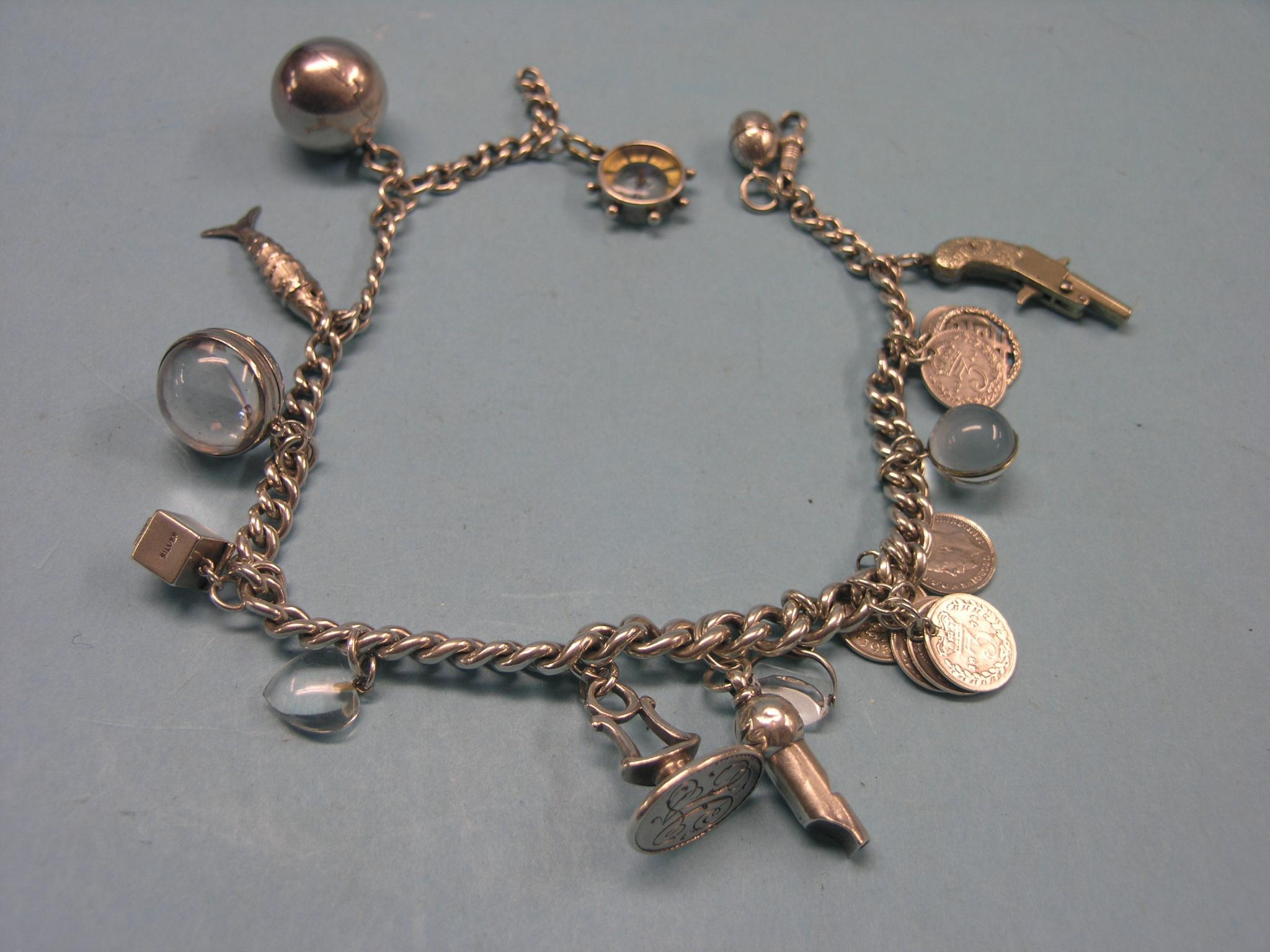 Appraisal: A silver charm bracelet charms include silver whistle seal and