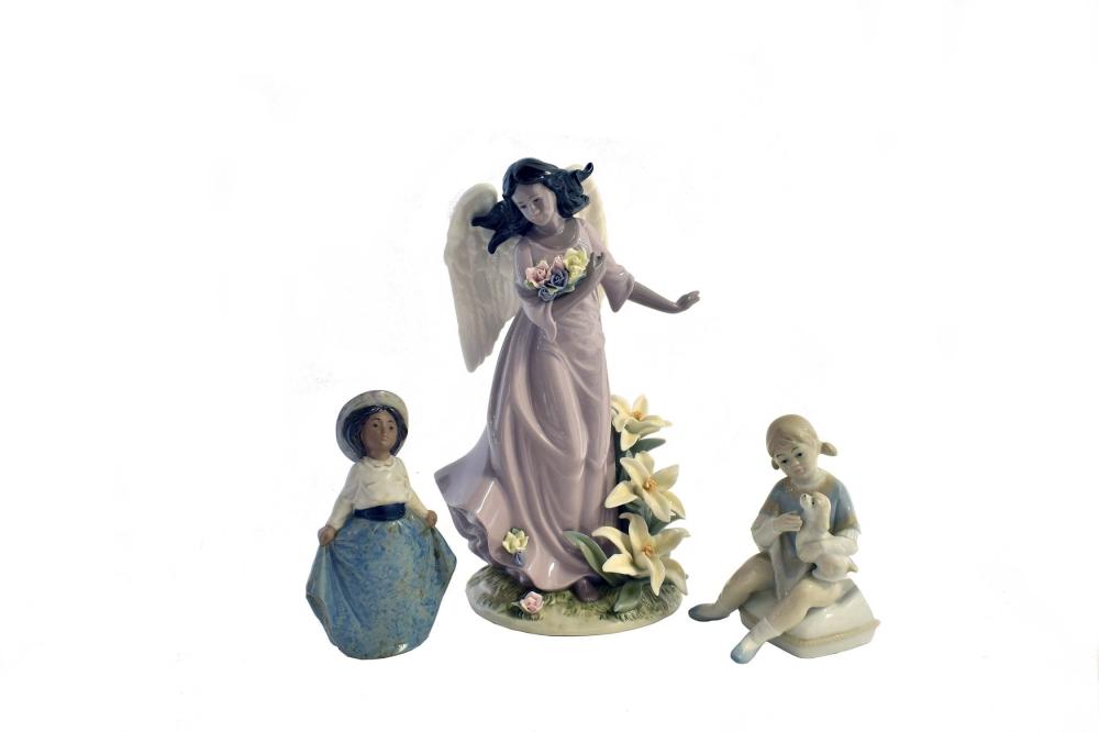 Appraisal: THREE PORCELAIN FIGURESThe first unmarked a angel with lilies the