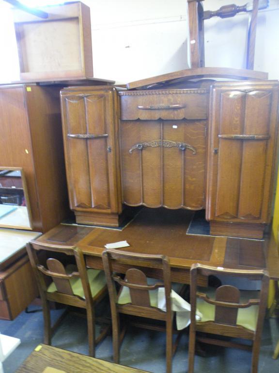 Appraisal: An oak dining room suite comprising sideboard draw leaf table