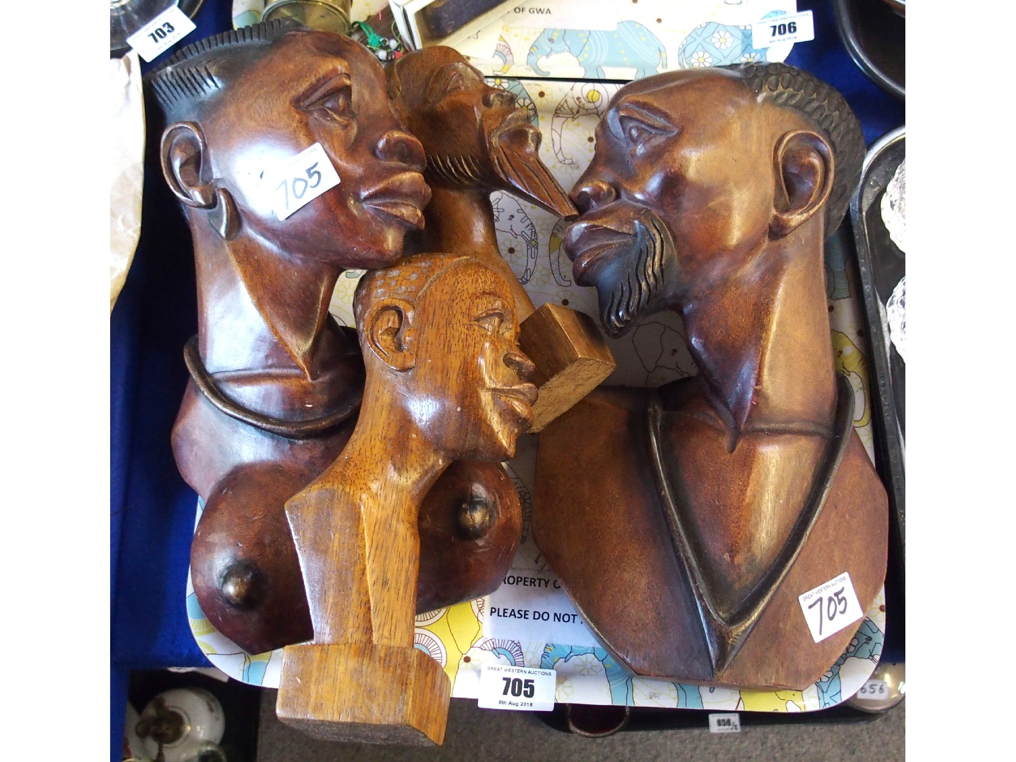 Appraisal: Tray comprising four carved mahogany African busts