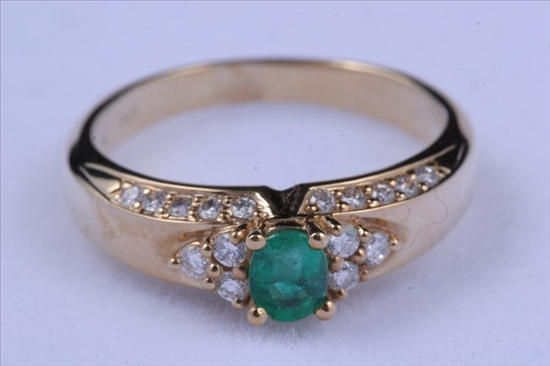 Appraisal: K YELLOW GOLD DIAMOND AND EMERALD RING Oval emerald centered