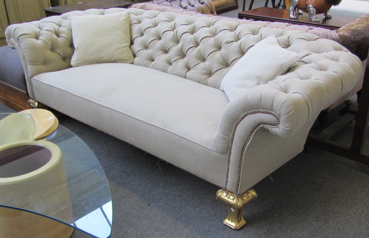 Appraisal: A low button back Chesterfield sofa with brass studded upholstery