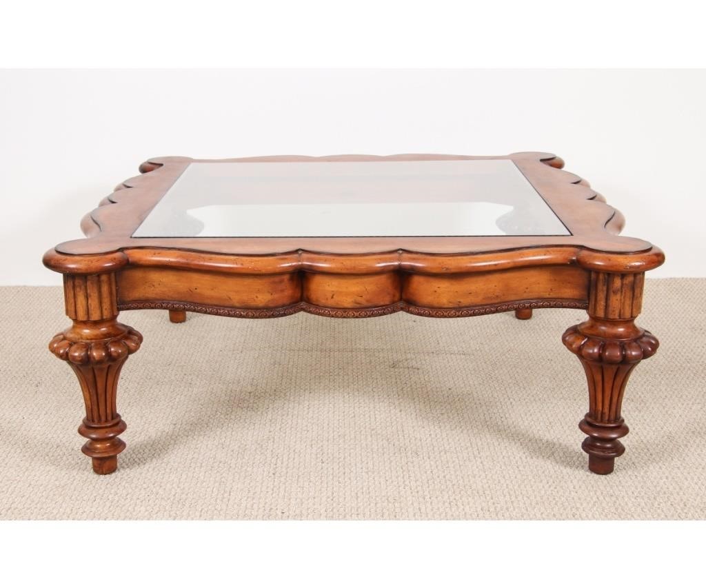 Appraisal: Ornate large fruitwood glass top cocktail table labed Baker Furniture