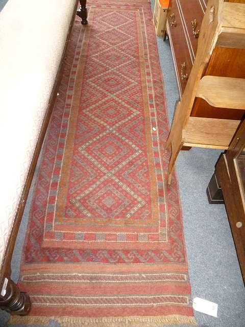 Appraisal: AN ORIENTAL RED GROUND RUNNER with diamond design to the