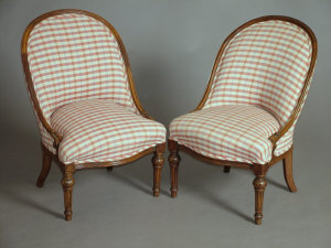 Appraisal: A pair of Edwardian rosewood nursing chairs the curved backs