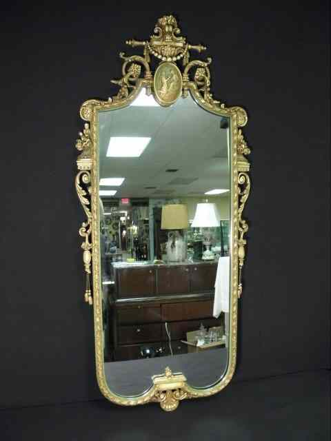 Appraisal: Large green and gold gilt rectangular wall mirror Small figural