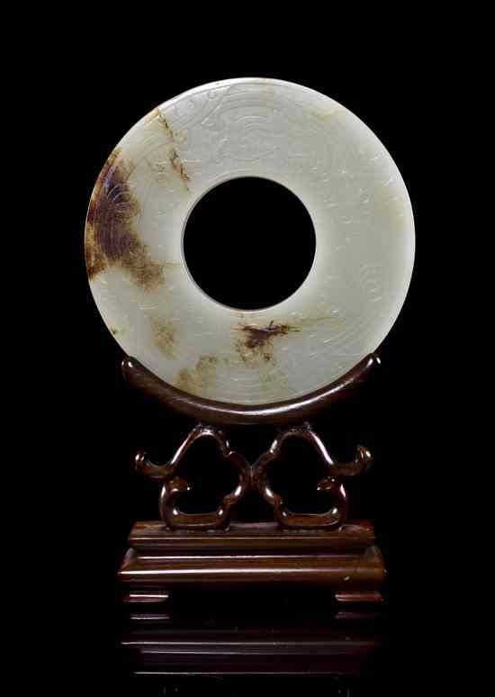 Appraisal: A White Jade Archaistic Bi having brown veining and inclusions