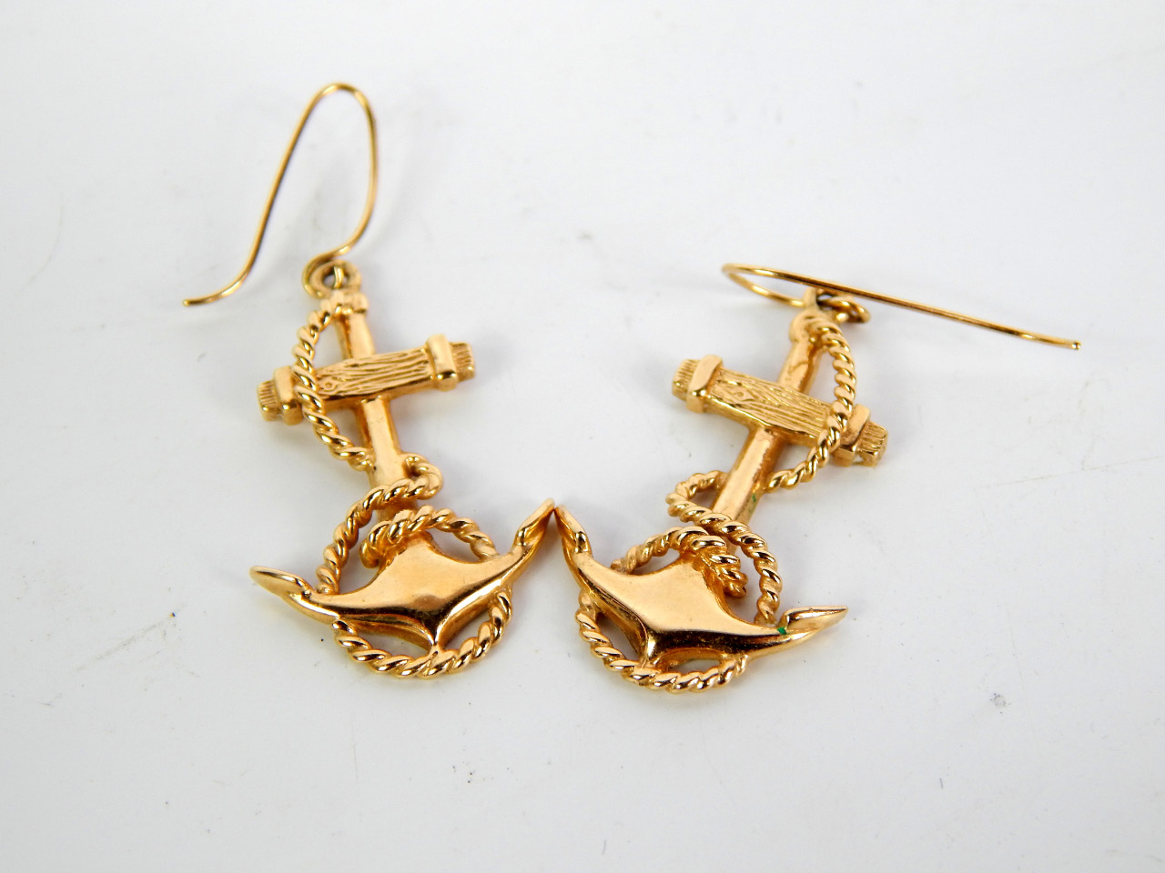 Appraisal: A pair of yellow metal furled anchor earrings on a