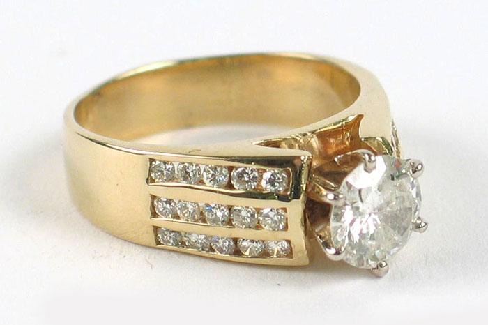 Appraisal: DIAMOND AND FOURTEEN KARAT GOLD RING centering a round brilliant-cut