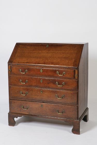 Appraisal: A GEORGE III OAK BUREAU with a sloping fall enclosing