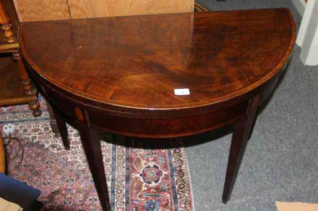 Appraisal: A GEORGE III MAHOGANY DEMI-LUNE CARD TABLE with crossbanded border