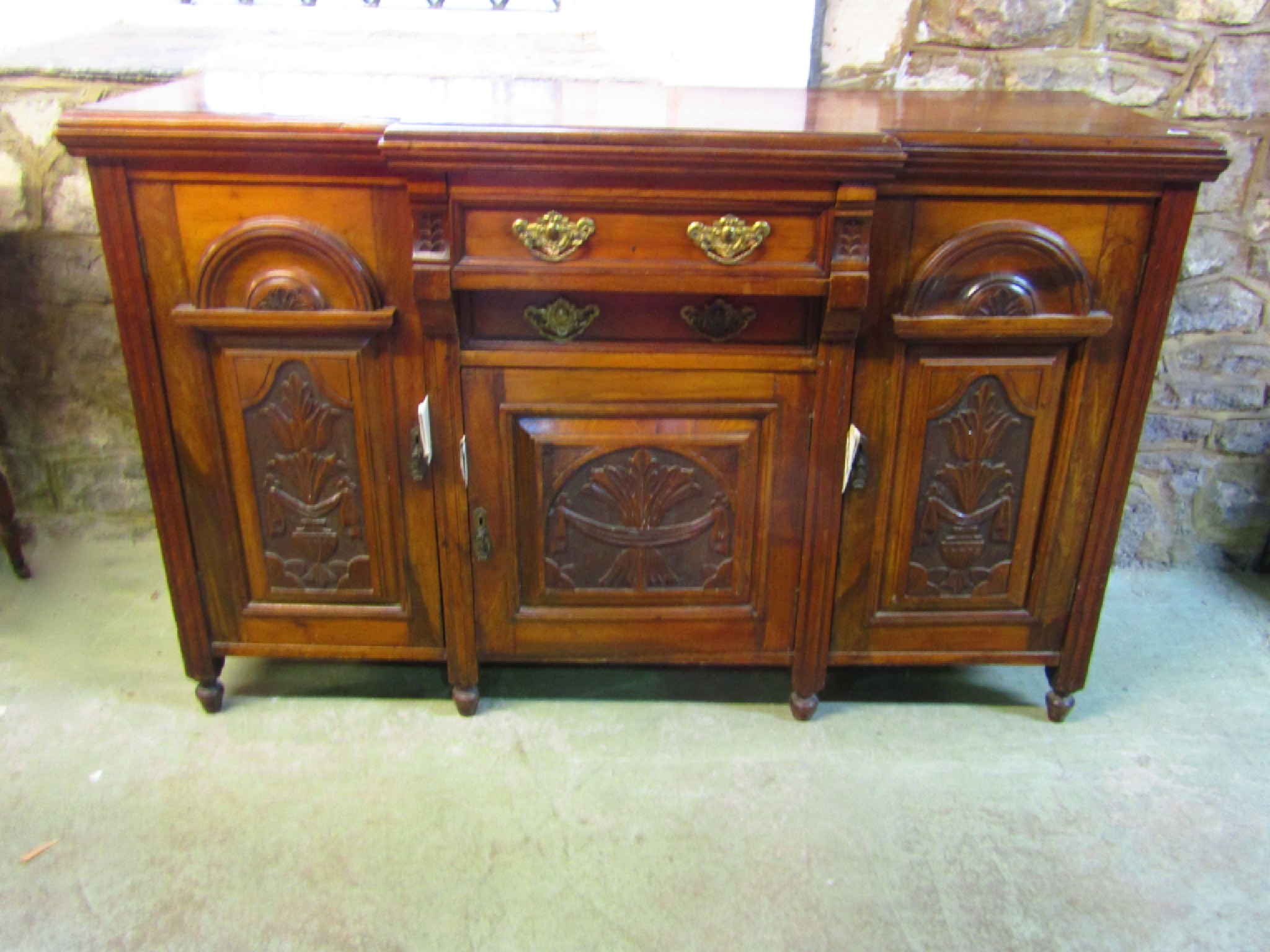 Appraisal: A late Victorian walnut sideboard with shallow breakfront enclosed by