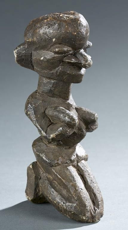 Appraisal: Kneeling female figure A kneeling female figure Guinea Kissi style