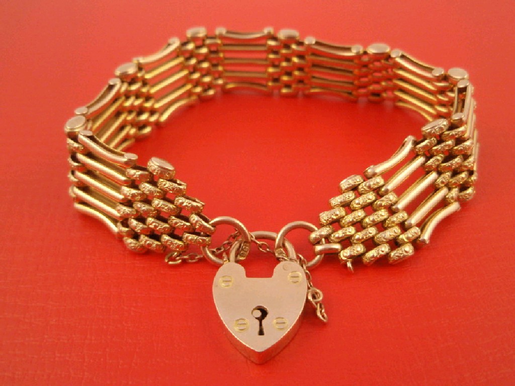 Appraisal: A bi-colour five bar gate bracelet with padlock clasp stamped