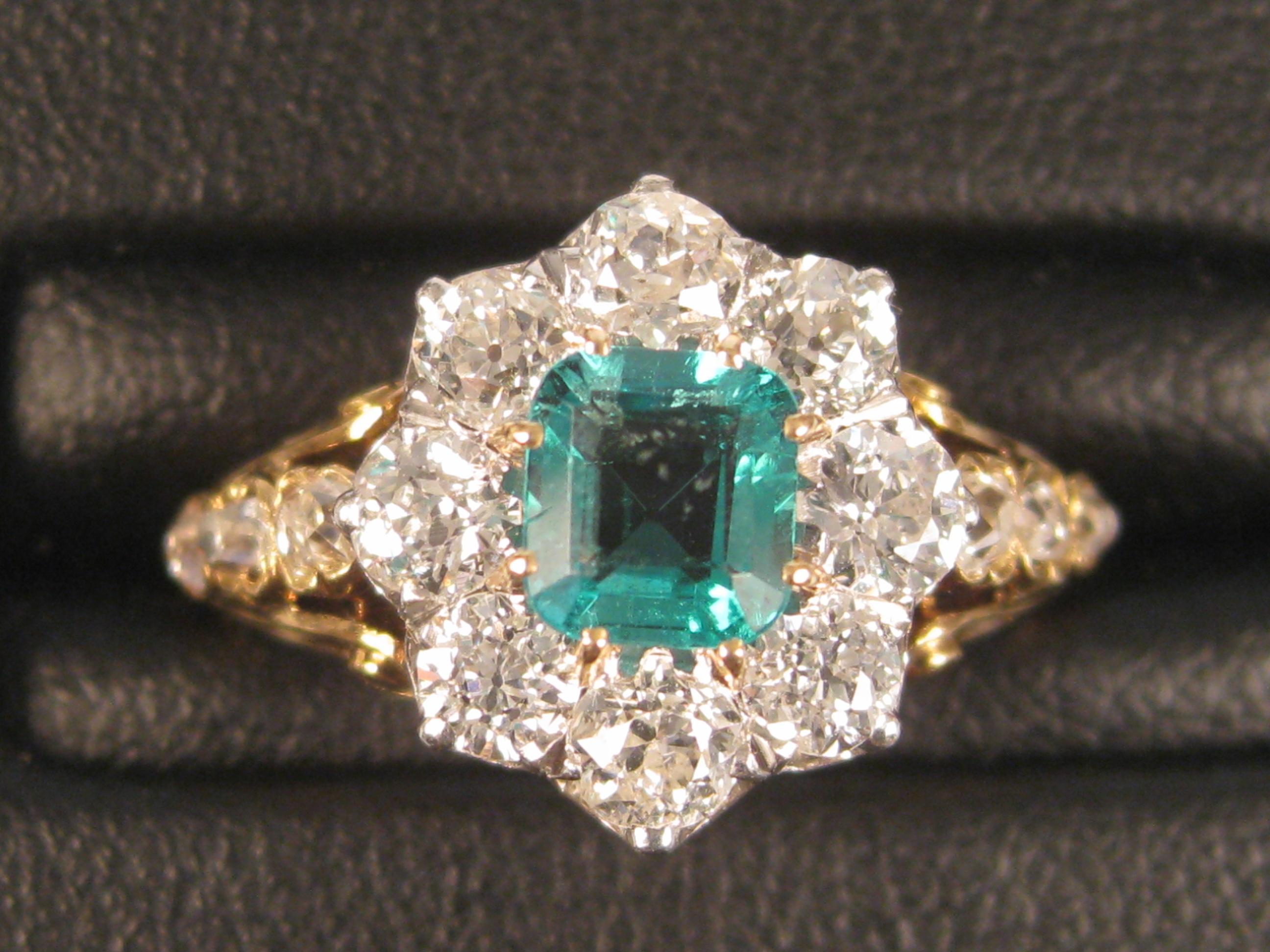 Appraisal: An Emerald and Diamond Ring the square-cut claw--set emerald surrounded