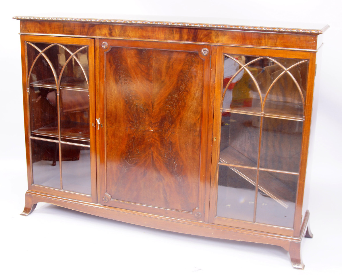 Appraisal: An early thC mahogany cabinet bookcase with gadrooned top over