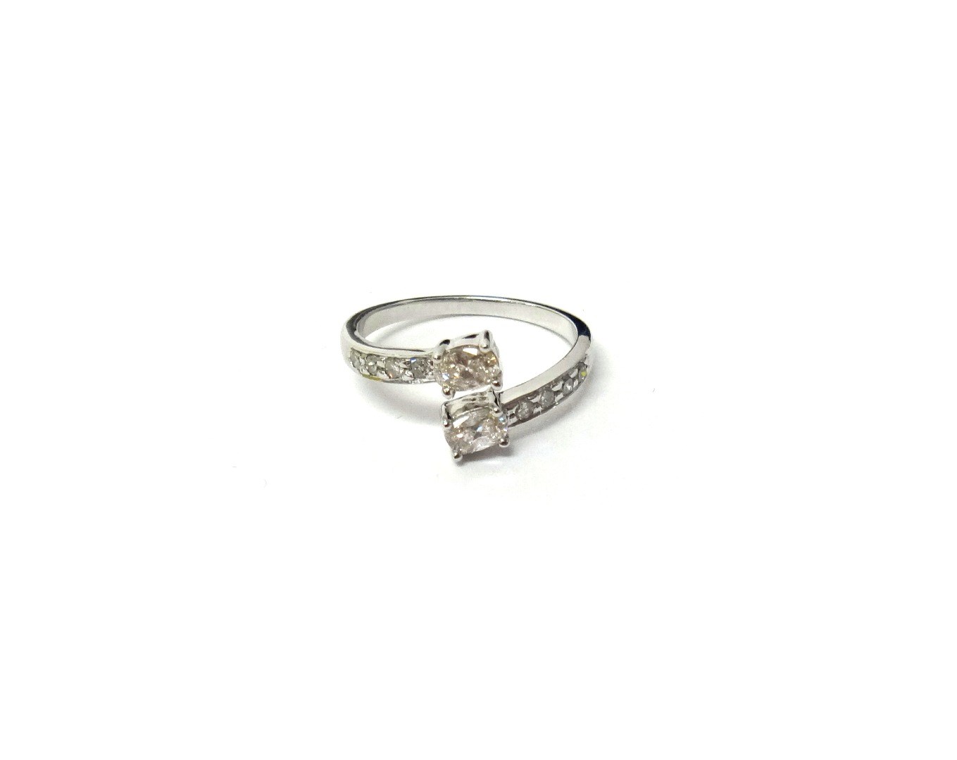 Appraisal: A diamond ring in a twistover openwork design claw set